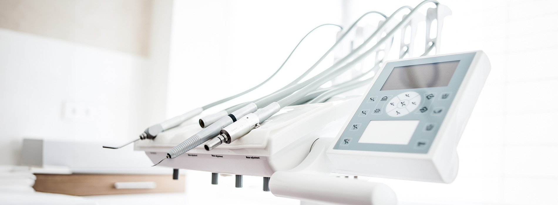 The image shows a collection of medical equipment on a table with various tubes and wires attached, against a blurred background.