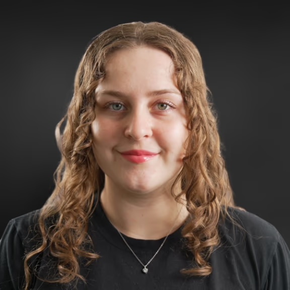 The image features two individuals with different hairstyles, one wearing a black t-shirt and the other with curly hair, both looking directly at the camera against a dark background.