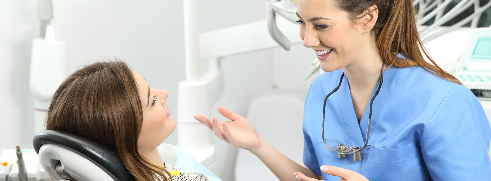 The image shows a dental office setting with a female dentist and patient, where the dentist is smiling and interacting with the patient.