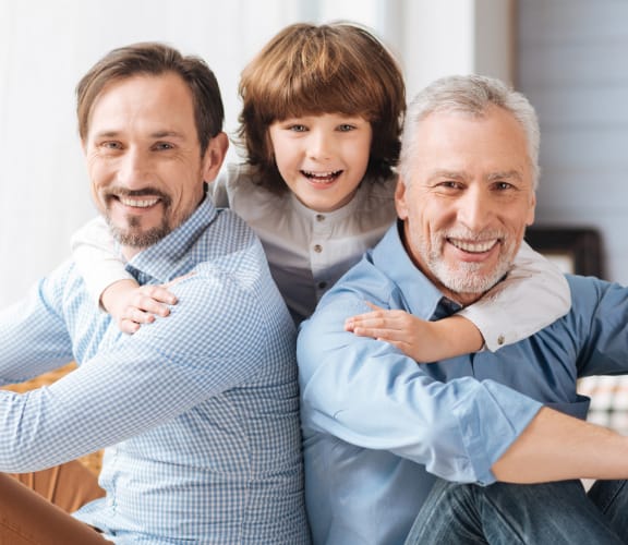 3 generations of men sitting on the front porch and smiling