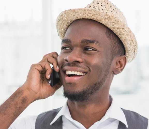 Man standing up in an office and talking on his cell phone